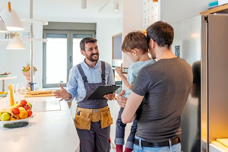 Image of technician working with family. AC Maintenance Checklist.